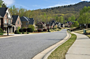 HOA community street with single family homes and manicured landscaping