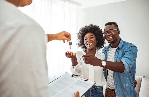 handing a key to couple | condo fees