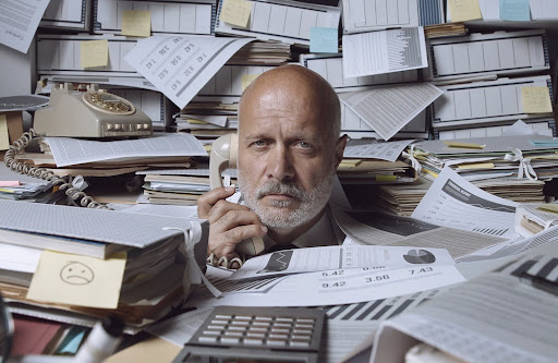 man in middle of papers | consult an hoa management company