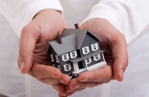 holding a miniature house | consult an hoa management company