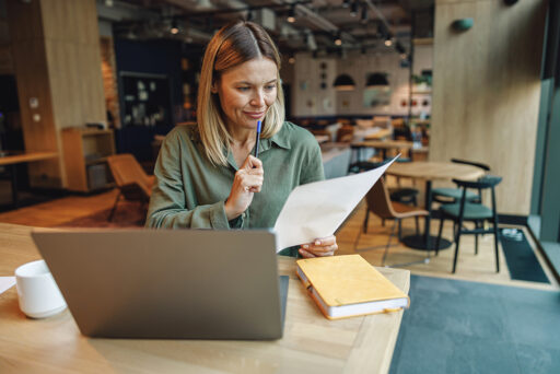 Focused woman analyst working with documents and a laptop | hoa performance review